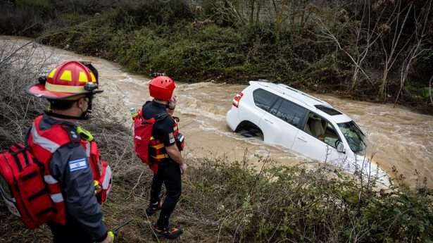 Zo mooi als het winterweer is, het kan ook levens­gevaarlijk zijn. Israëlische reddings­teams staan bij een auto die op 16 januari was gestrand door de over­stroming bij de ingang van Jeruzalem. 