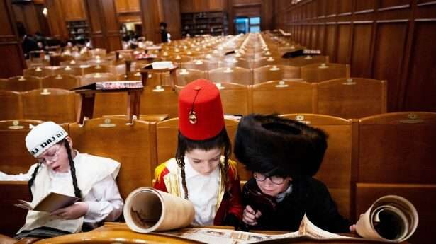Orthodoxe Joodse jongens lezen de boekrol van Esther in Jeruzalem.
