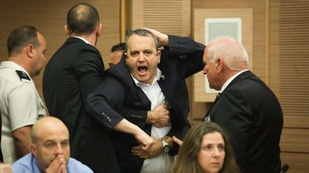 Botsingen over de grondwet gaan door in het hele land. Parlementslid Gilad Kariv wordt uit de Knesset geëscorteerd na zijn reactie tijdens een commissievergadering.
